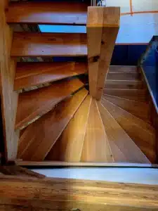 Escalier tournant en bois massif, marches rayonnantes et poteau poteau de soutien en chêne rustique.